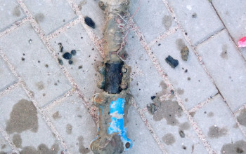 To zdjęcie przedstawia skorodowane przyłącze z rury stalowej, które jest uszczelnione za pomocą metalowych opasek naprawczych.